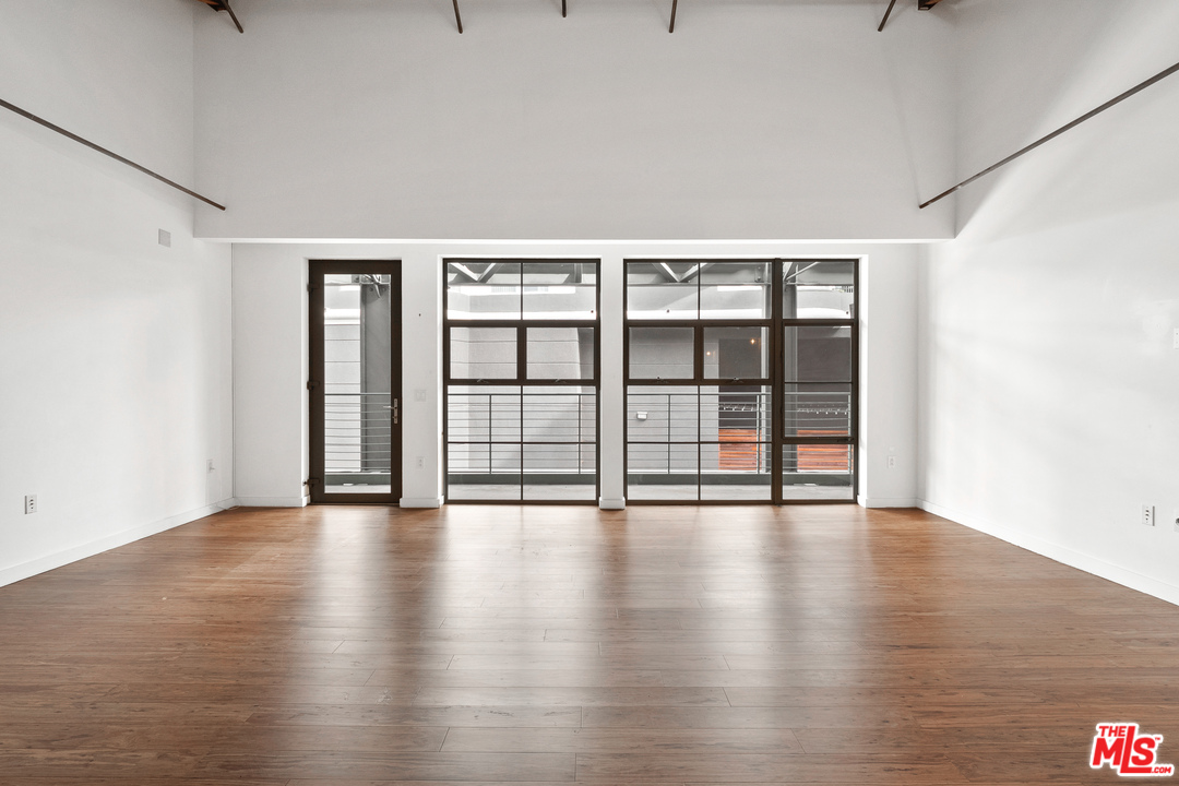 1046 Princeton Drive, Unit 210 Venice, CA 90292 - Photo 14 of 37 a view of an empty room with wooden floor and fan