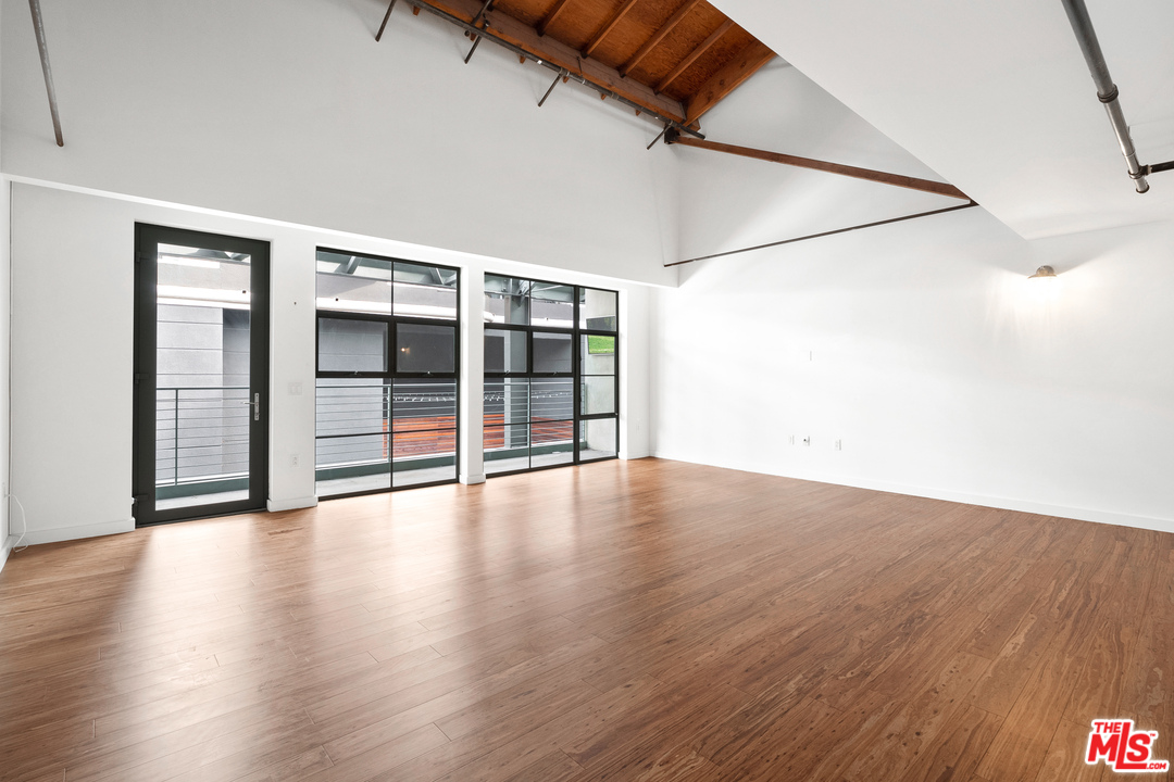 1046 Princeton Drive, Unit 210 Venice, CA 90292 - Photo 15 of 37 an empty room with wooden floor and windows