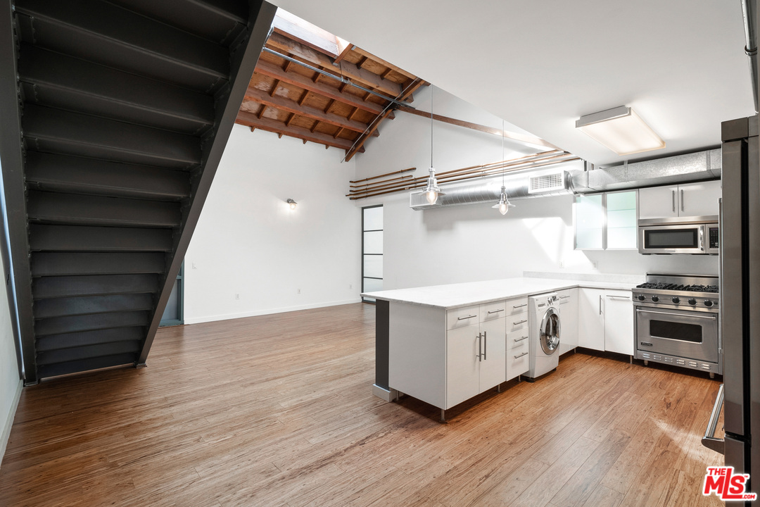 1046 Princeton Drive, Unit 210 Venice, CA 90292 - Photo 8 of 37 a kitchen with stainless steel appliances white cabinets and wooden floors