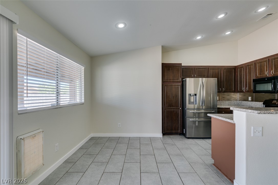 2028 Rustler Ridge Avenue North Las Vegas, NV 89031 - Photo 15 of 40 A well-lit kitchen area features sleek tile flooring and modern stainless steel appliances.