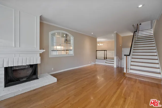 a view of a room with wooden floors and chandelier