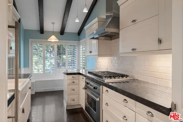 a kitchen with granite countertop stove a sink and cabinets