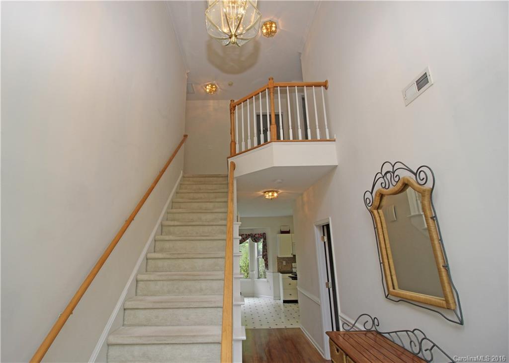 7300 Reedy Creek Road, Unit 59 Charlotte, NC 28215 - Photo 15 of 24 a view of staircase with wooden floor and a chandelier