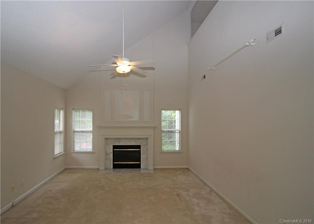 7300 Reedy Creek Road, Unit 59 Charlotte, NC 28215 - Photo 6 of 24 an empty room with windows and fireplace