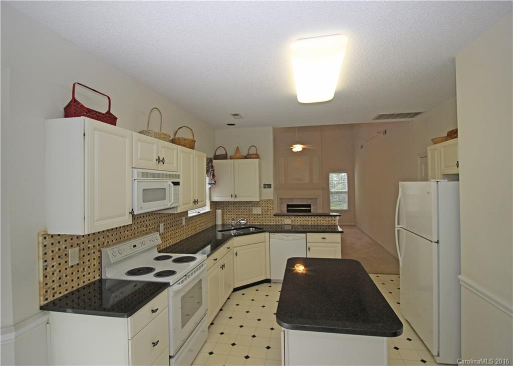 7300 Reedy Creek Road, Unit 59 Charlotte, NC 28215 - Photo 7 of 24 a kitchen with granite countertop a sink stove and refrigerator