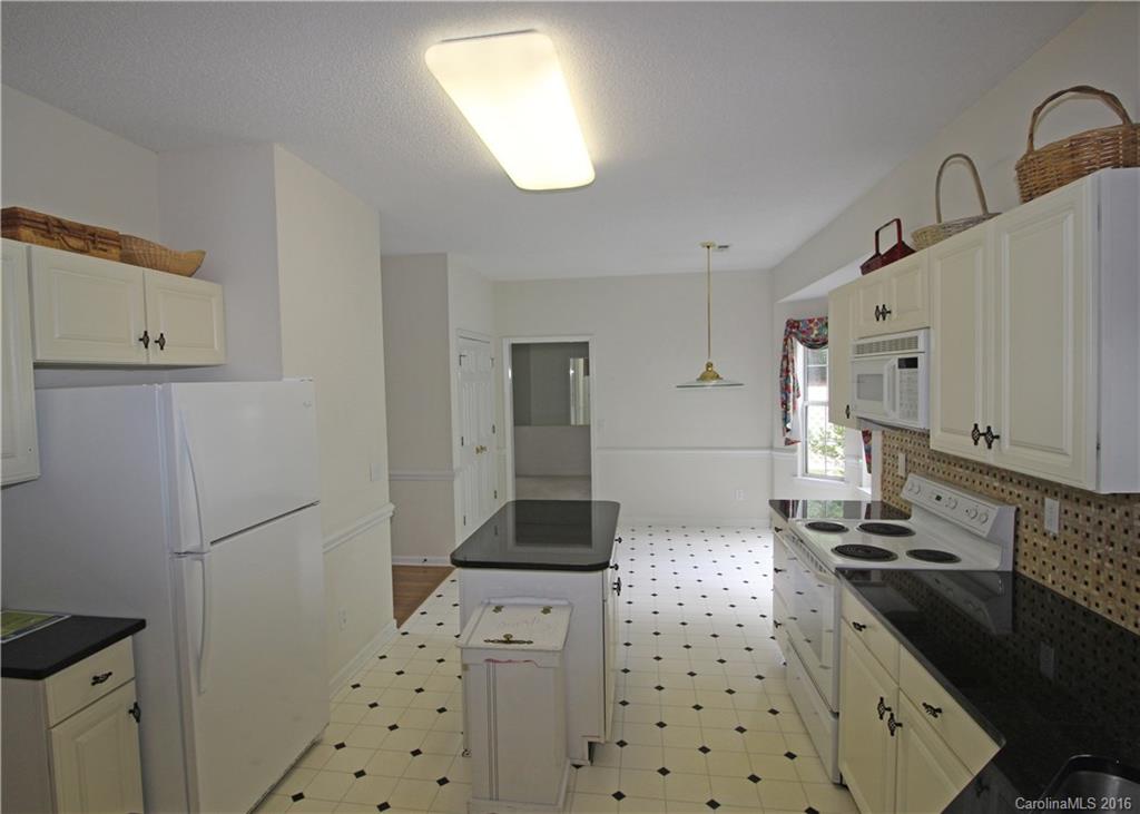 7300 Reedy Creek Road, Unit 59 Charlotte, NC 28215 - Photo 9 of 24 a kitchen with granite countertop a sink a stove and refrigerator