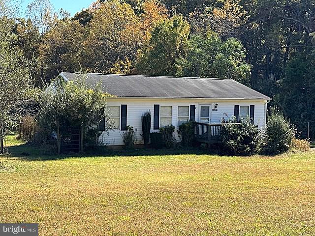 a front view of house with yard and trees in the background