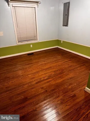 a view of a room with wooden floor and white walls
