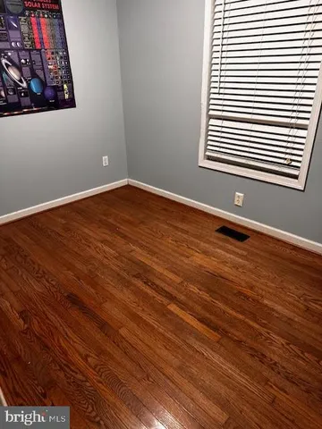 a view of a room with wooden floor and a window