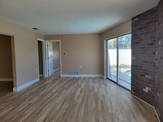wooden floor in an empty room with a window