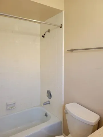 a white toilet sitting next to a bath tub