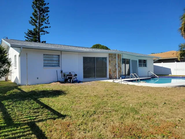 a view of a house with backyard and sitting area