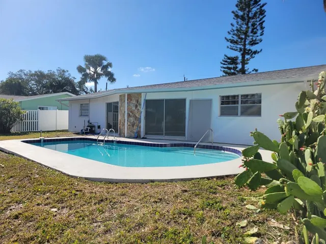 a view of a house with pool and a yard