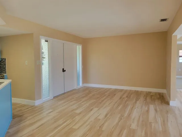 a view of an empty room with wooden floor
