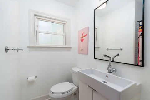 a bathroom with a toilet sink and mirror