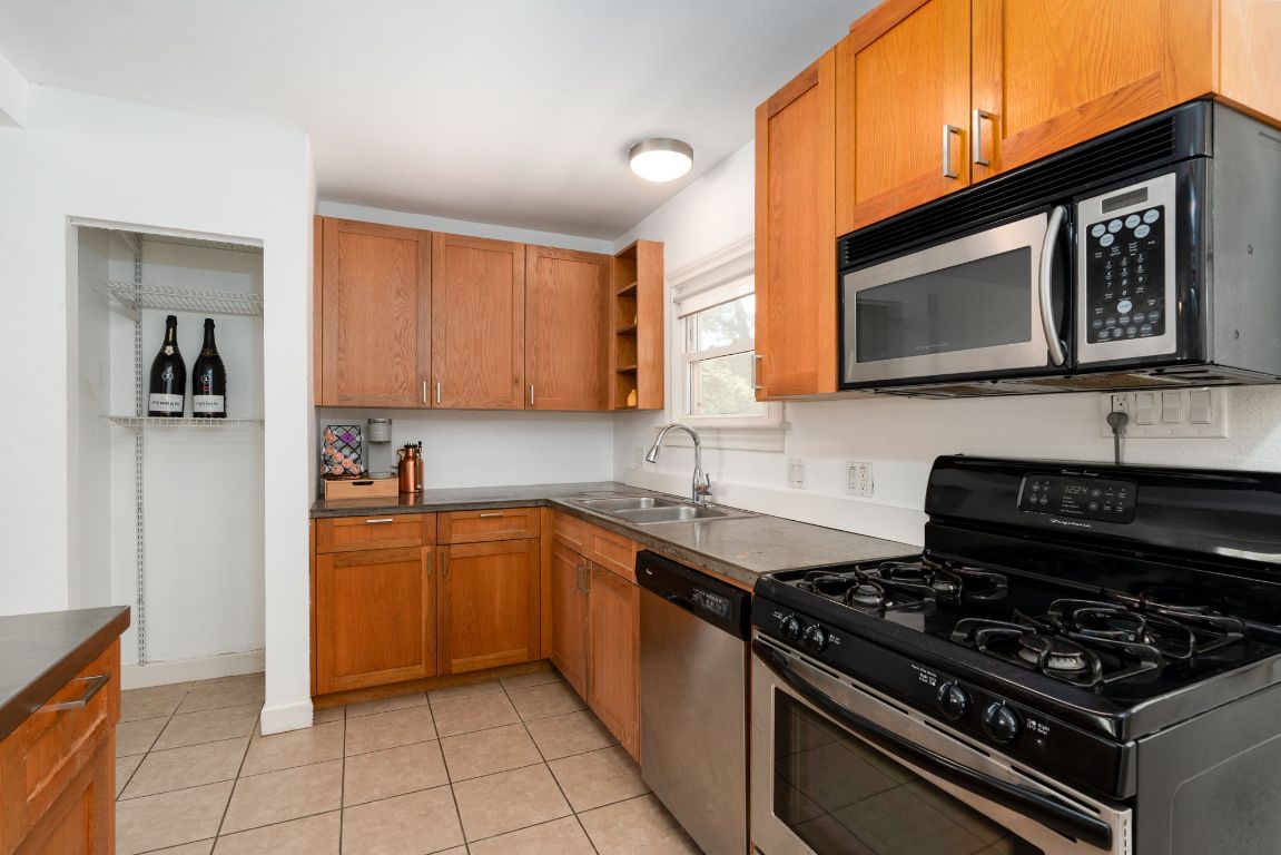 746 Springdale Road Austin, TX 78702 - Photo 9 of 20 a kitchen with stainless steel appliances granite countertop a stove and a microwave