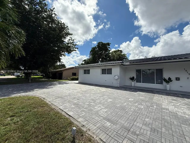 a view of a house with a patio and a yard