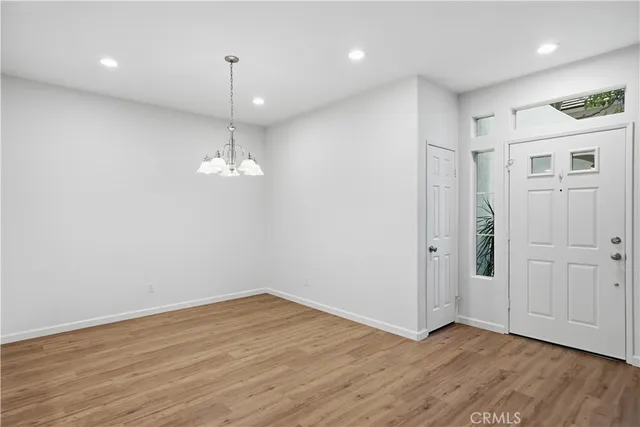 a view of empty room with wooden floor and ceiling fan