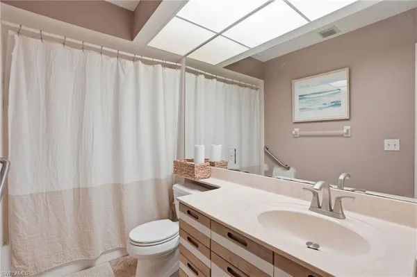 a bathroom with a sink a toilet and shower curtain