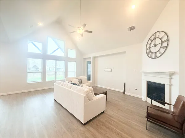 a living room with furniture a fireplace and a large window