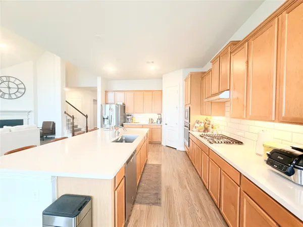 a view of a kitchen with kitchen island a large window a sink and counter space