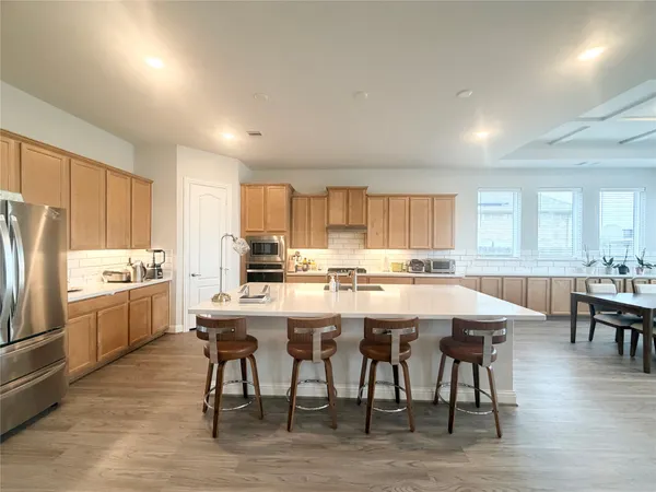 a kitchen with a table chairs refrigerator and cabinets