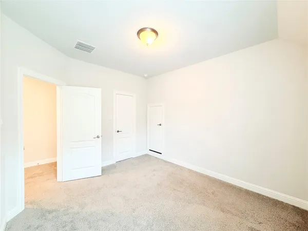 a spacious bedroom with a bed and a window