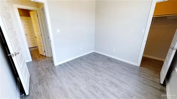 an empty room with wooden floor and stairs