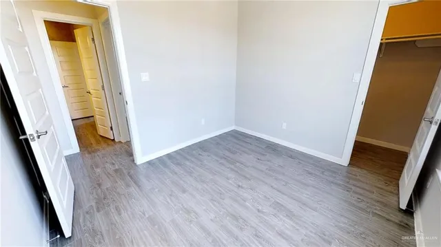 an empty room with wooden floor and stairs