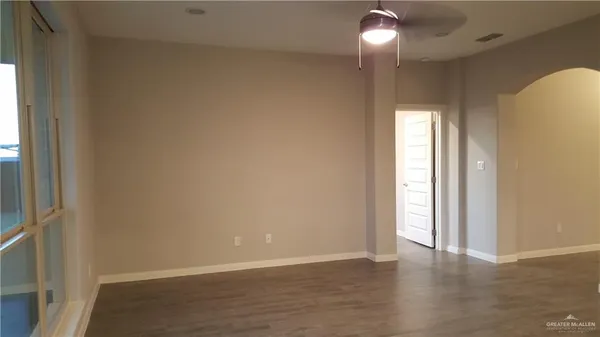 a view of empty room with window and wooden floor