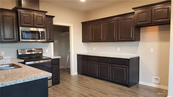 a kitchen with stainless steel appliances granite countertop wooden cabinets and a stove top oven