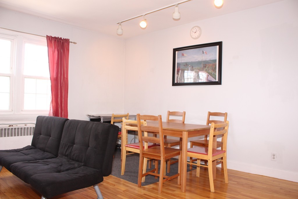 112 Maple Street, Unit 6 Malden, MA 02148 - Photo 4 of 6 a living room with furniture wooden floor and a large window