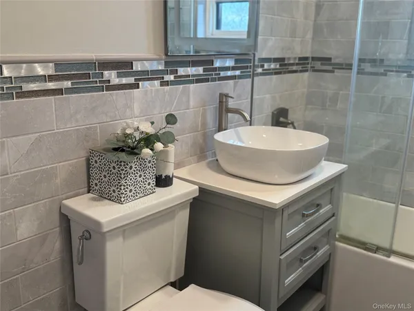 a bathroom with a granite countertop sink toilet and shower