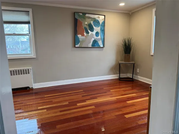 a view of a hallway with wooden floor and a potted plant