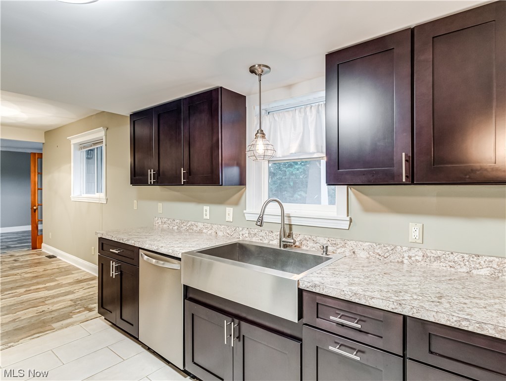 4349 Broadview Road Richfield, OH 44286 - Photo 11 of 20 Kitchen featuring stainless steel dishwasher, hanging light fixtures, light countertops, dark brown cabinetry, and light tile flooring