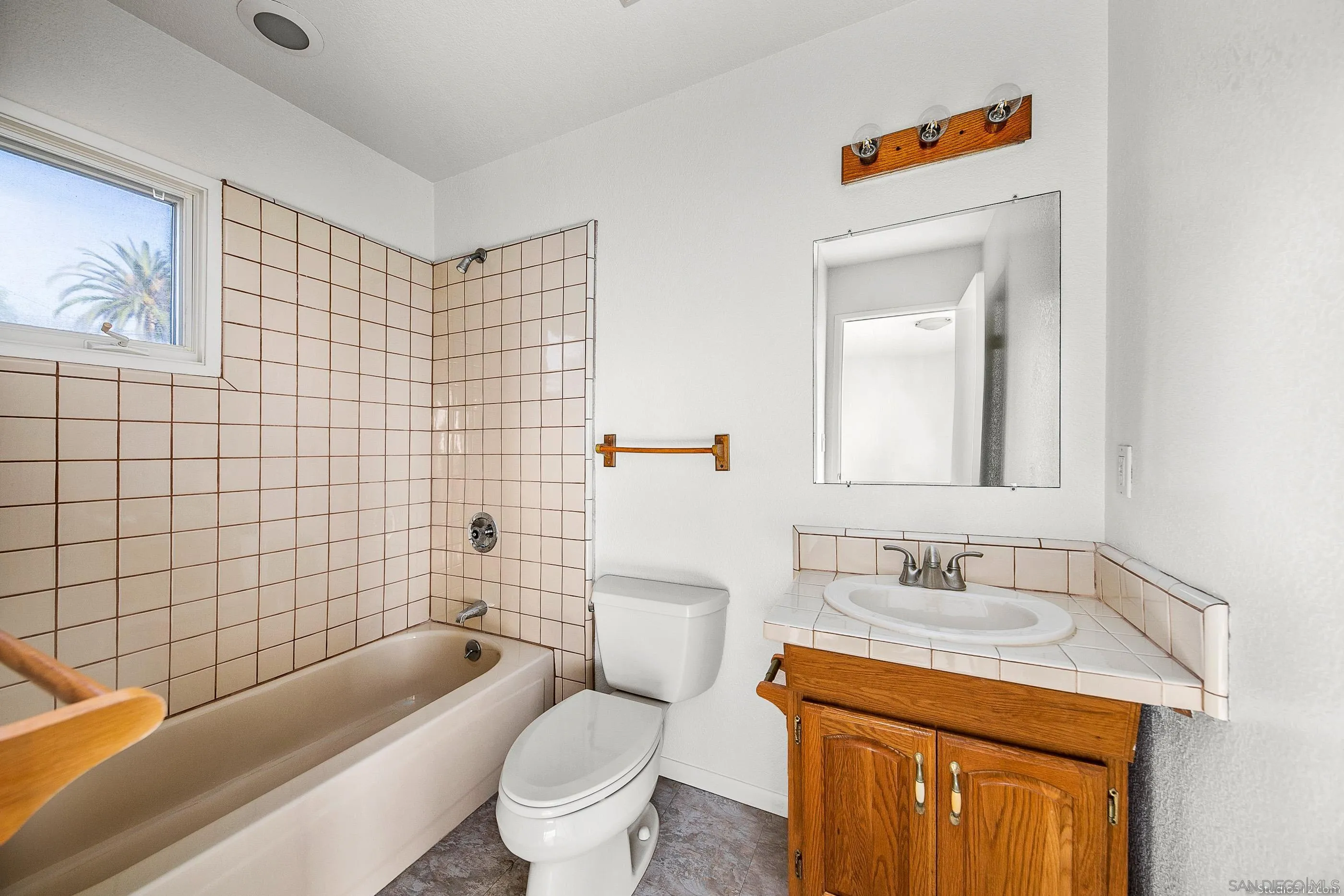 1112 Oceanic Drive Encinitas, CA 92024 - Photo 18 of 32 a bathroom with a granite countertop toilet a sink and a mirror