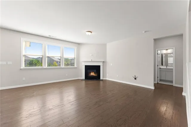 an empty room with wooden floor and a window