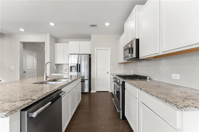 a kitchen with stainless steel appliances granite countertop a sink stove and refrigerator