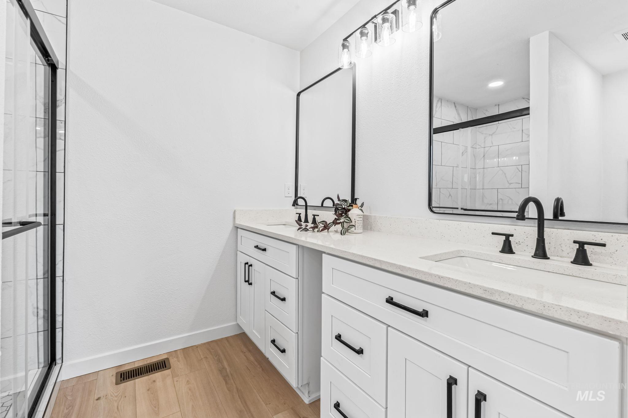 1117 Olds Ferry Road Weiser, ID 83672 - Photo 31 of 36 Bathroom with a shower stall, light wood-style floors, and double vanity