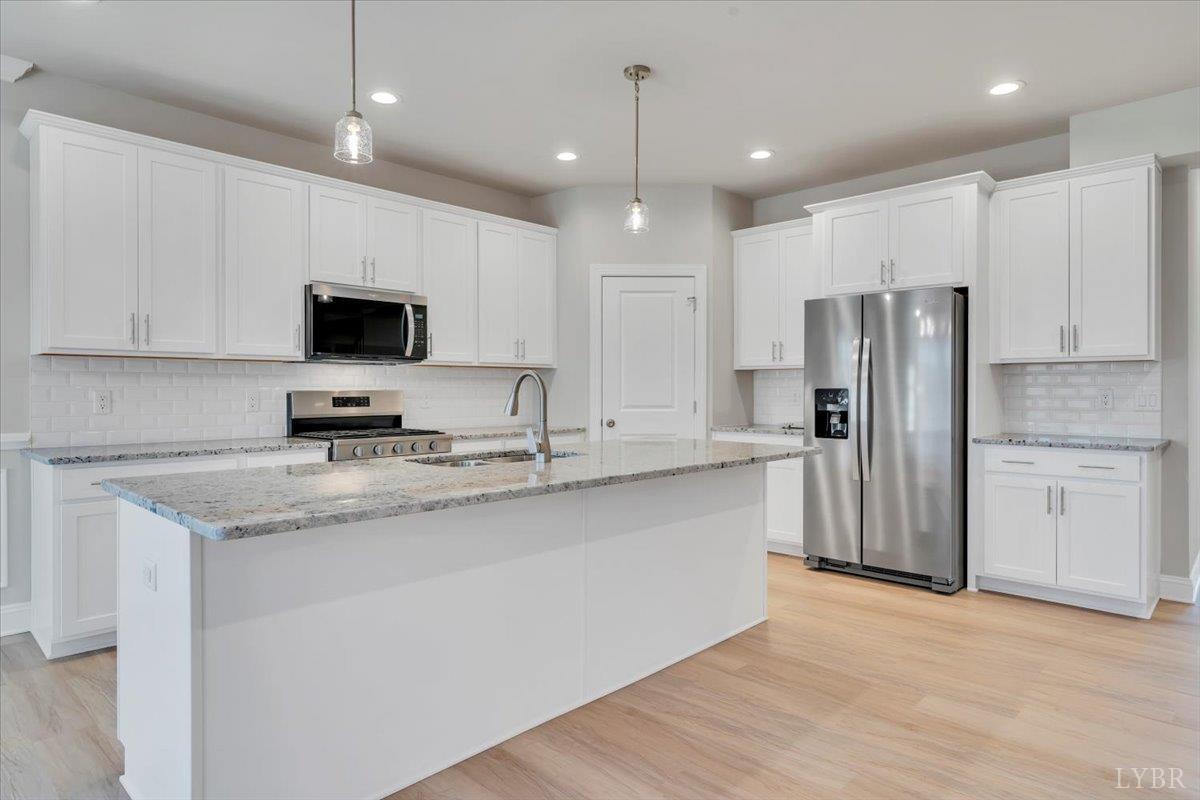 4715 Boonsboro Road Lynchburg, VA 24503 - Photo 10 of 28 a kitchen with kitchen island granite countertop a sink appliances and cabinets