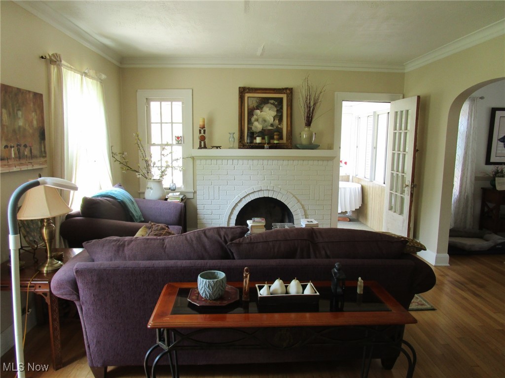 134 Ridgewood Drive Youngstown, OH 44512 - Photo 2 of 29 Living room with arched walkways, a fireplace, wood finished floors, and crown molding