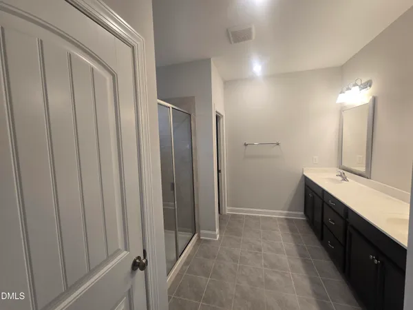 a bathroom with a double vanity sink toilet and shower