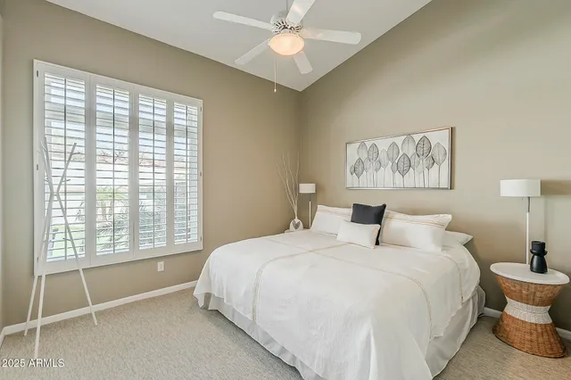 a spacious bedroom with a bed and a large window