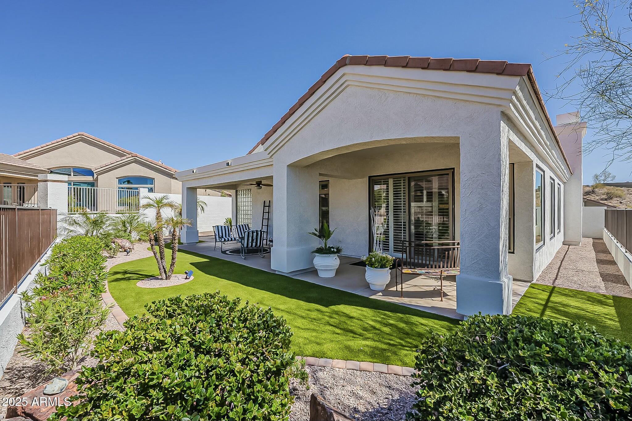 6334 East Viewmont Drive, Unit 29 Mesa, AZ 85215 - Photo 32 of 47 a front view of a house with a yard table and chairs