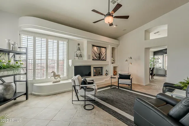a living room with furniture a fireplace and a large window