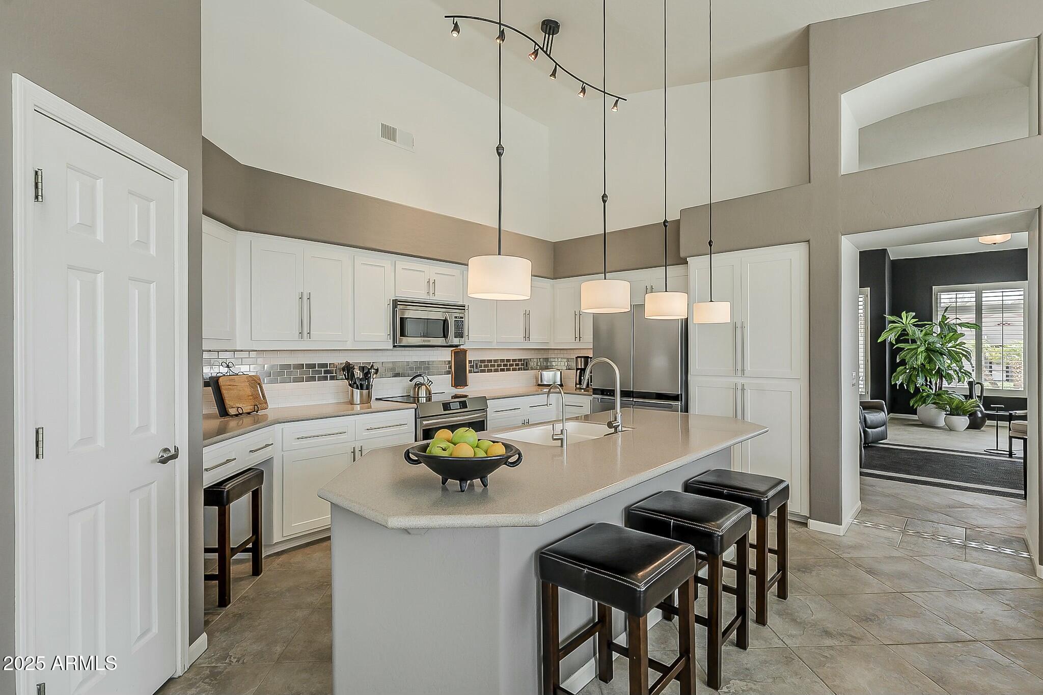 6334 East Viewmont Drive, Unit 29 Mesa, AZ 85215 - Photo 9 of 47 a kitchen with a sink a counter and chairs