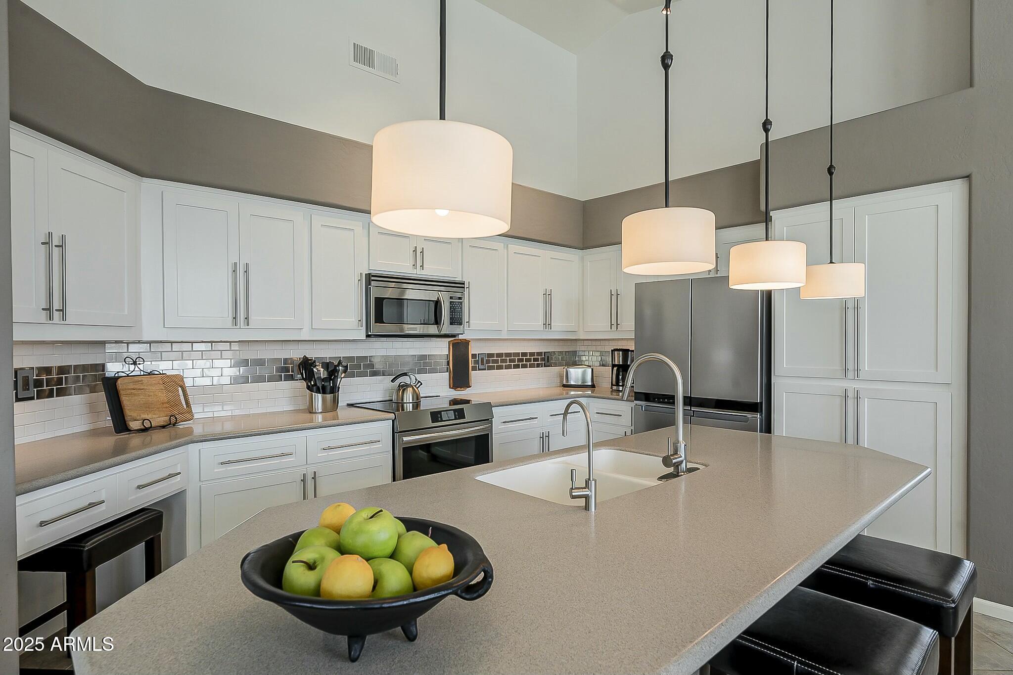 6334 East Viewmont Drive, Unit 29 Mesa, AZ 85215 - Photo 10 of 47 a kitchen with stainless steel appliances granite countertop a stove a sink a refrigerator a stove white cabinets and chairs