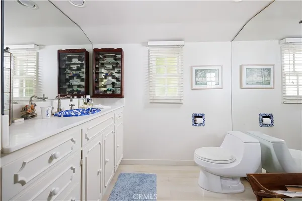 a bathroom with a sink a toilet a large mirror and shower