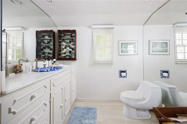 a bathroom with a sink a toilet a large mirror and shower