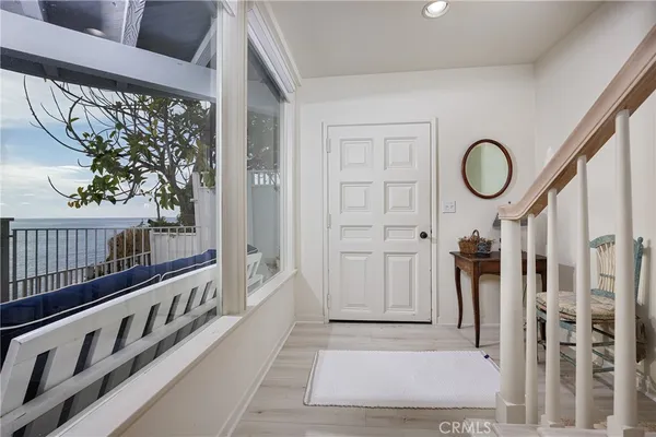 a view of a hallway with wooden floor and windows